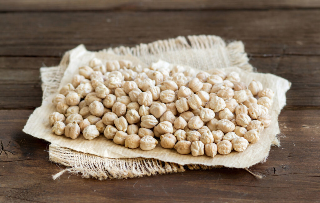 chickpeas on a piece of cloth at the top of wooden table 