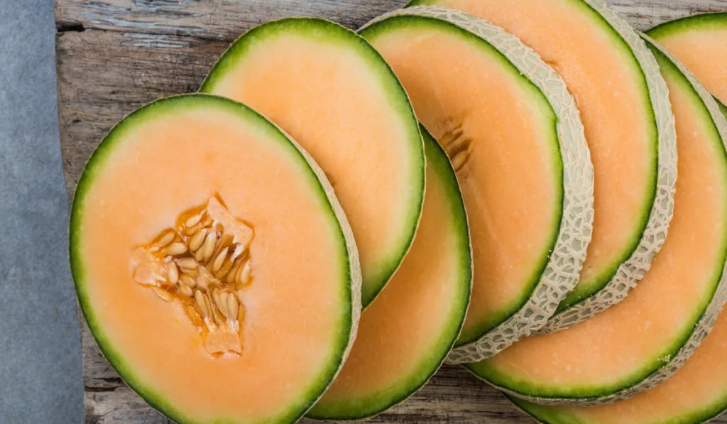 Cantaloupe melon slices on board
