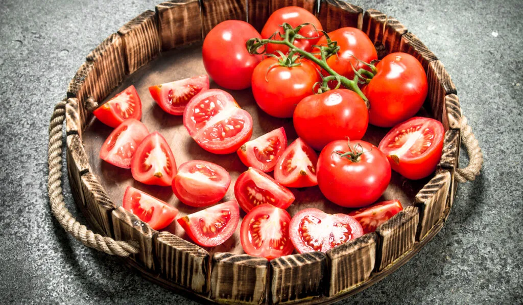 Fresh tomatoes on the tray. On rustic background.

