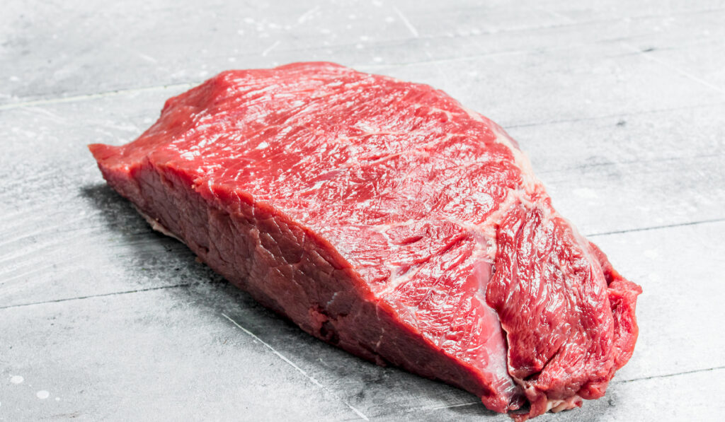 Raw meat. Piece of beef. On a rustic background